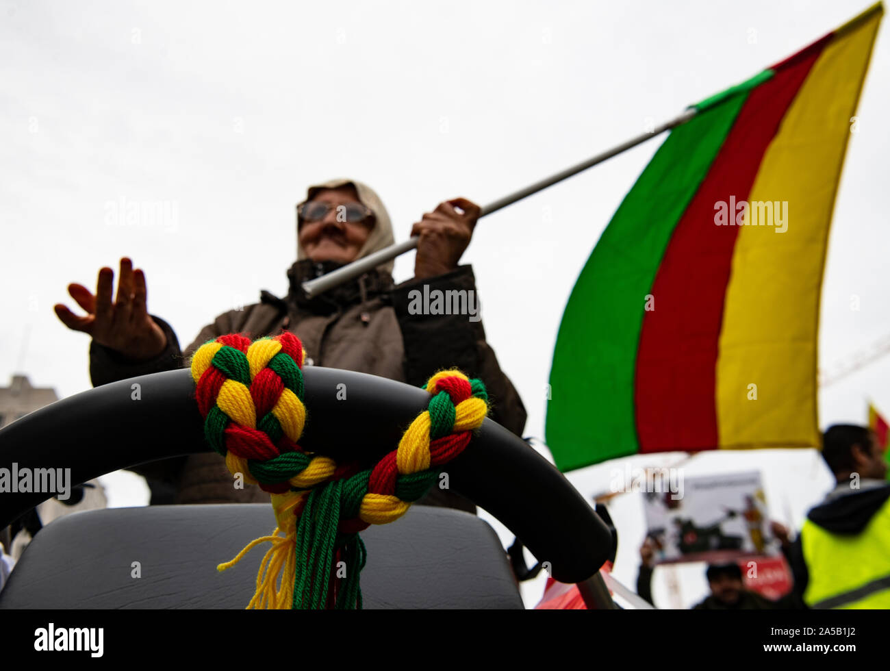 Berlin, Allemagne. 19 Oct, 2019. Un participant de la manifestation kurde contre l'offensive militaire turque dans le Nord de la Syrie se distingue avec un drapeau kurde derrière irhem3903. Crédit : Paul Zinken/dpa/Alamy Live News Banque D'Images