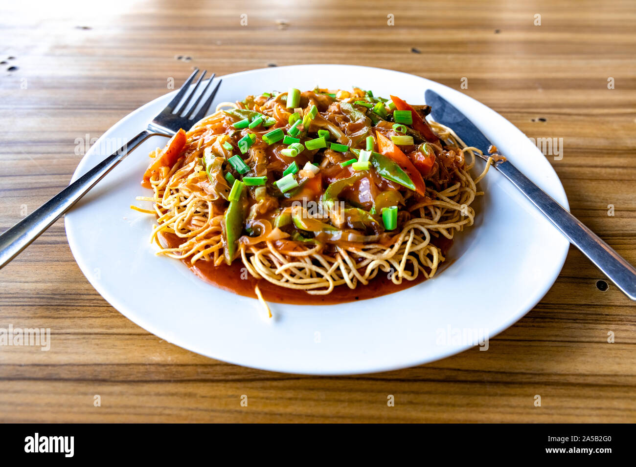 Chopsuey américain servi dans une assiette blanche sur la surface en bois Banque D'Images