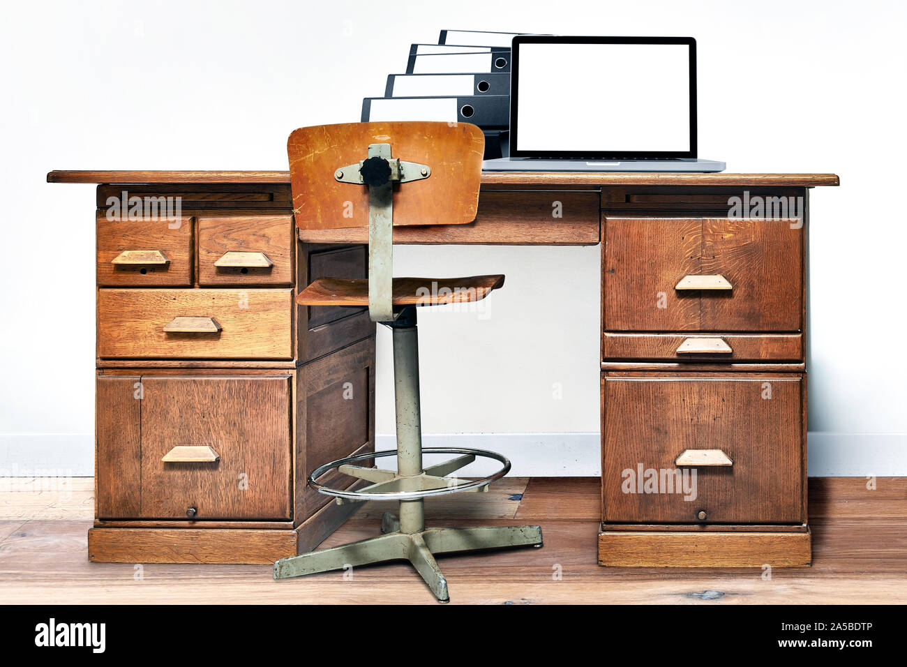 Ordinateur portable et étendu sur un dossier vintage 24 dans une chambre avec plancher en bois Banque D'Images