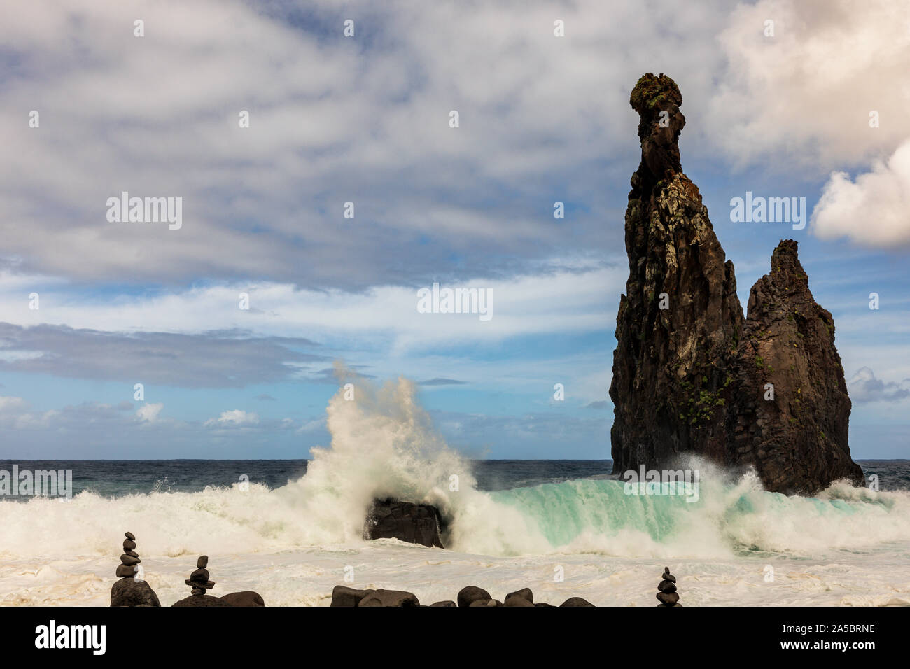 Les vagues déferlent sur les rochers à la plage de galets et de formations de roche volcanique à Ilheus da Rib, Ribeira da Janela, Madeira, Portugal Banque D'Images