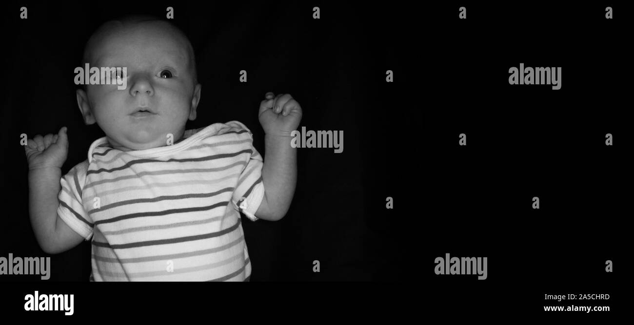 Un Bebe De 2 Mois Pose Sur Un Fond Noir Parfait Pour Les Memes Avec Copie Espace Photo Stock Alamy