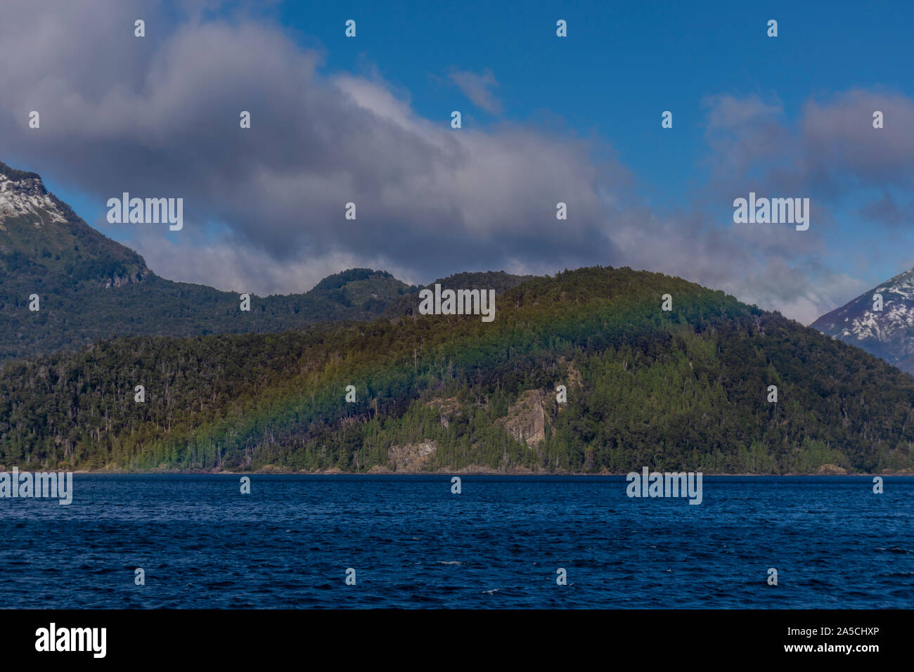 Scène d'un arc-en-ciel coloré au-dessus d'un lac à l'encontre des Andes, Parc National Los Alerces, Argentine Banque D'Images