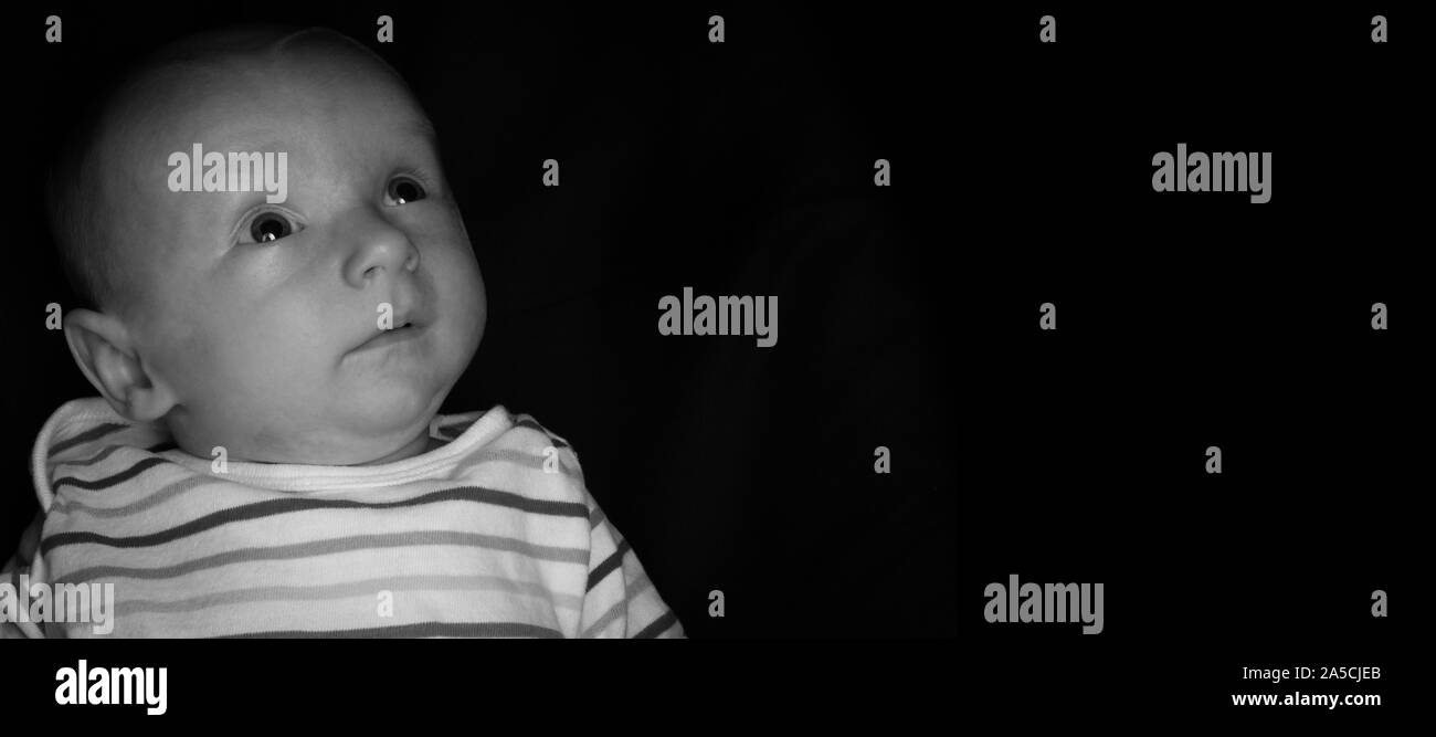 Un Bebe De 2 Mois Pose Sur Un Fond Noir Parfait Pour Les Memes Avec Copie Espace Photo Stock Alamy