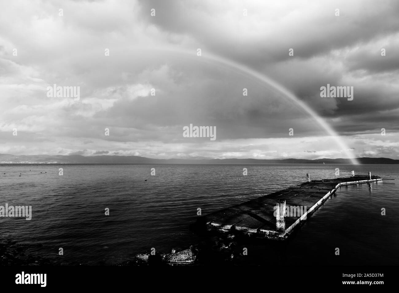 Belle vue sur un arc-en-ciel sur un quai sur un lac Trasimeno (Ombrie, Italie) Banque D'Images