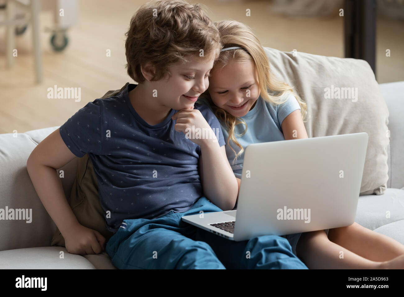 Little Boy and girl using laptop, regarder les dessins animés ou la lecture Banque D'Images