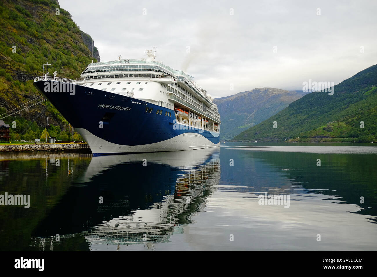 Bateau de croisière dans le fjord de Flåm, Norvège. Entre les montagnes pendant une journée nuageuse. Vert des arbres et le calme de l'eau. Banque D'Images