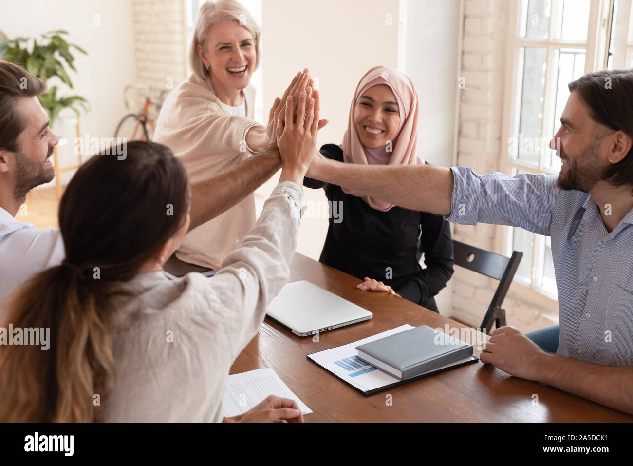 L'équipe d'entreprises multiculturelles avec succès les gens accordent une grande réunion à cinq Banque D'Images