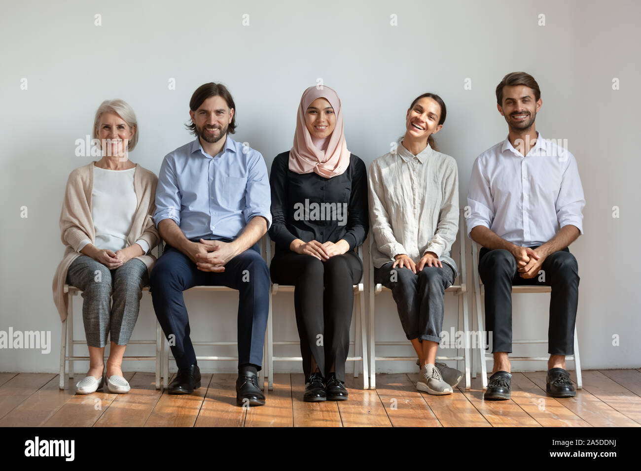 Les gens d'affaires professionnel multiculturel souriant s'asseoir sur des chaises en ligne Banque D'Images