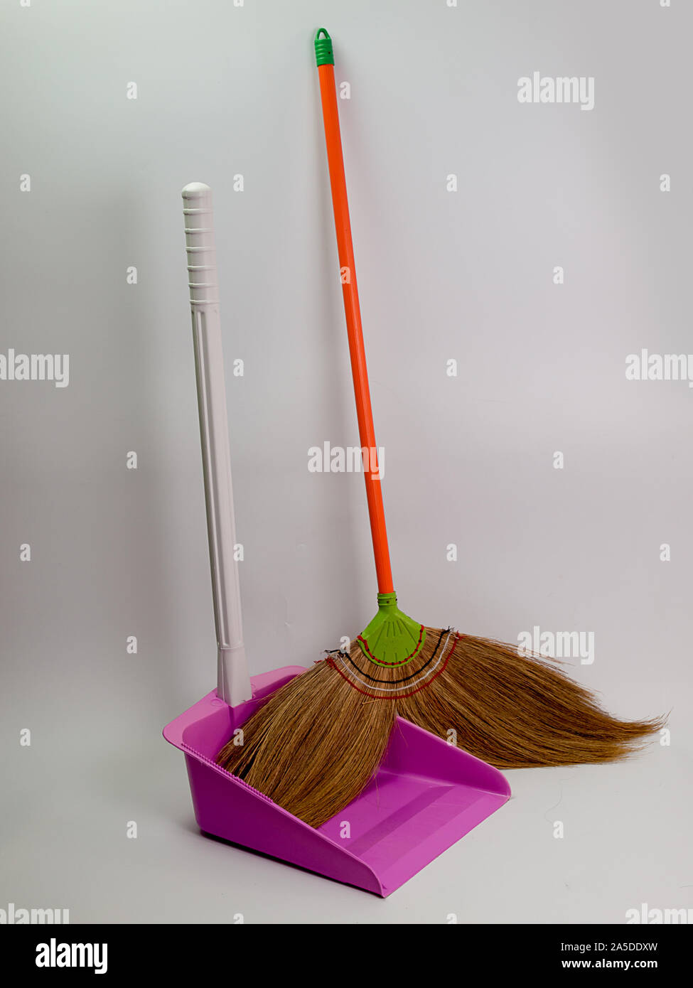 Pelle et un balai pour le nettoyage sur fond blanc Banque D'Images