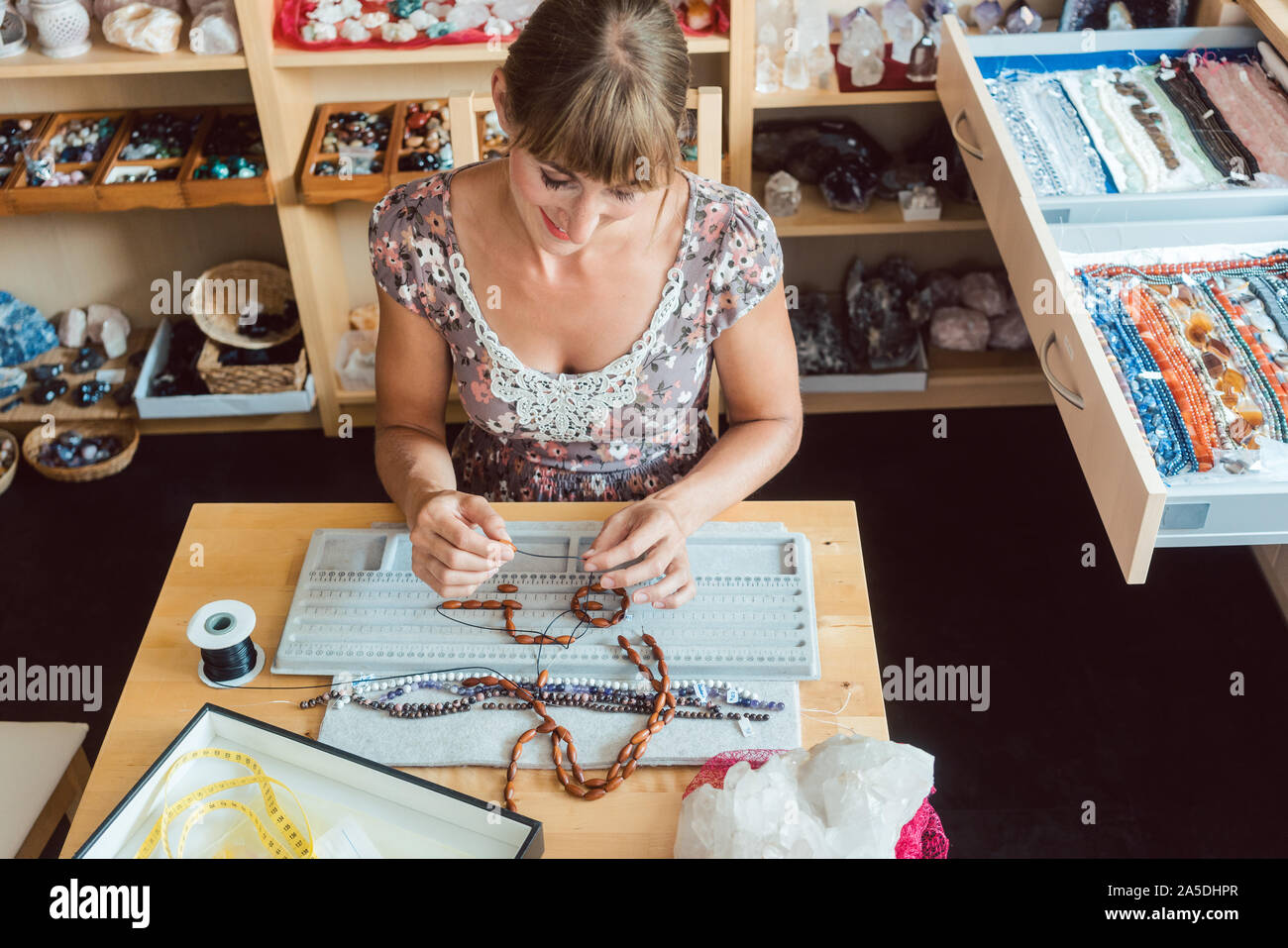 Femme au travail sur un collier de pierres précieuses comme un passe-temps Banque D'Images