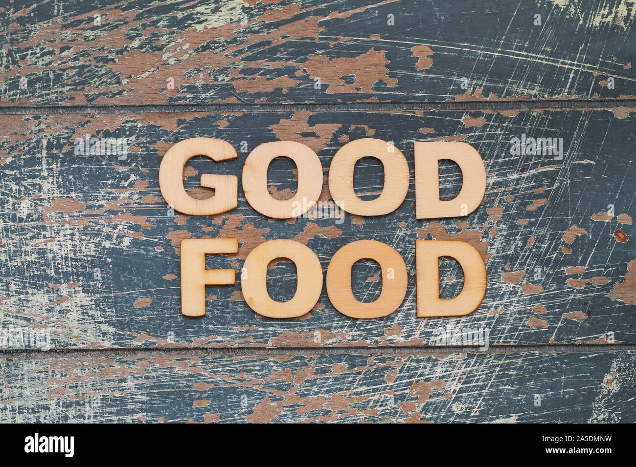 Bonne nourriture écrit avec des lettres en bois rustique sur la surface bleue Banque D'Images