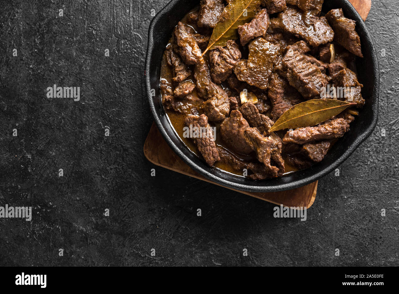 Ragoût de viande. L'étuvée boeuf au vin rouge, vue du dessus, copiez l'espace. La viande de boeuf rôtie. La viande de boeuf braisé au passage. La viande de bœuf mijotés dans la poêle en fonte. Banque D'Images