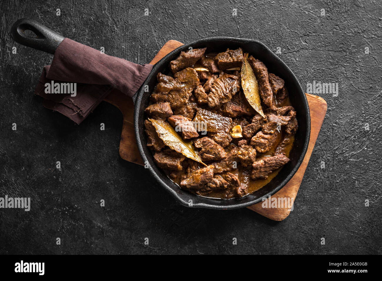 Ragoût de viande. L'étuvée boeuf au vin rouge, vue du dessus, copiez l'espace. La viande de boeuf rôtie. La viande de boeuf braisé au passage. La viande de bœuf mijotés dans la poêle en fonte. Banque D'Images