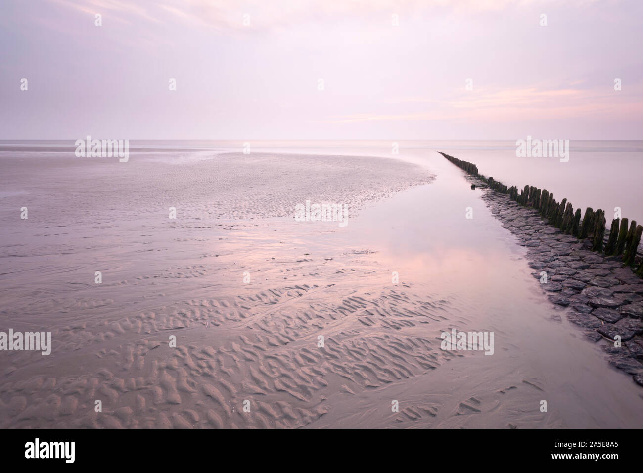 Une ligne de poteaux qui mène à la mer du Nord en Norderney, Allemagne. L'exposition à long shot. Banque D'Images