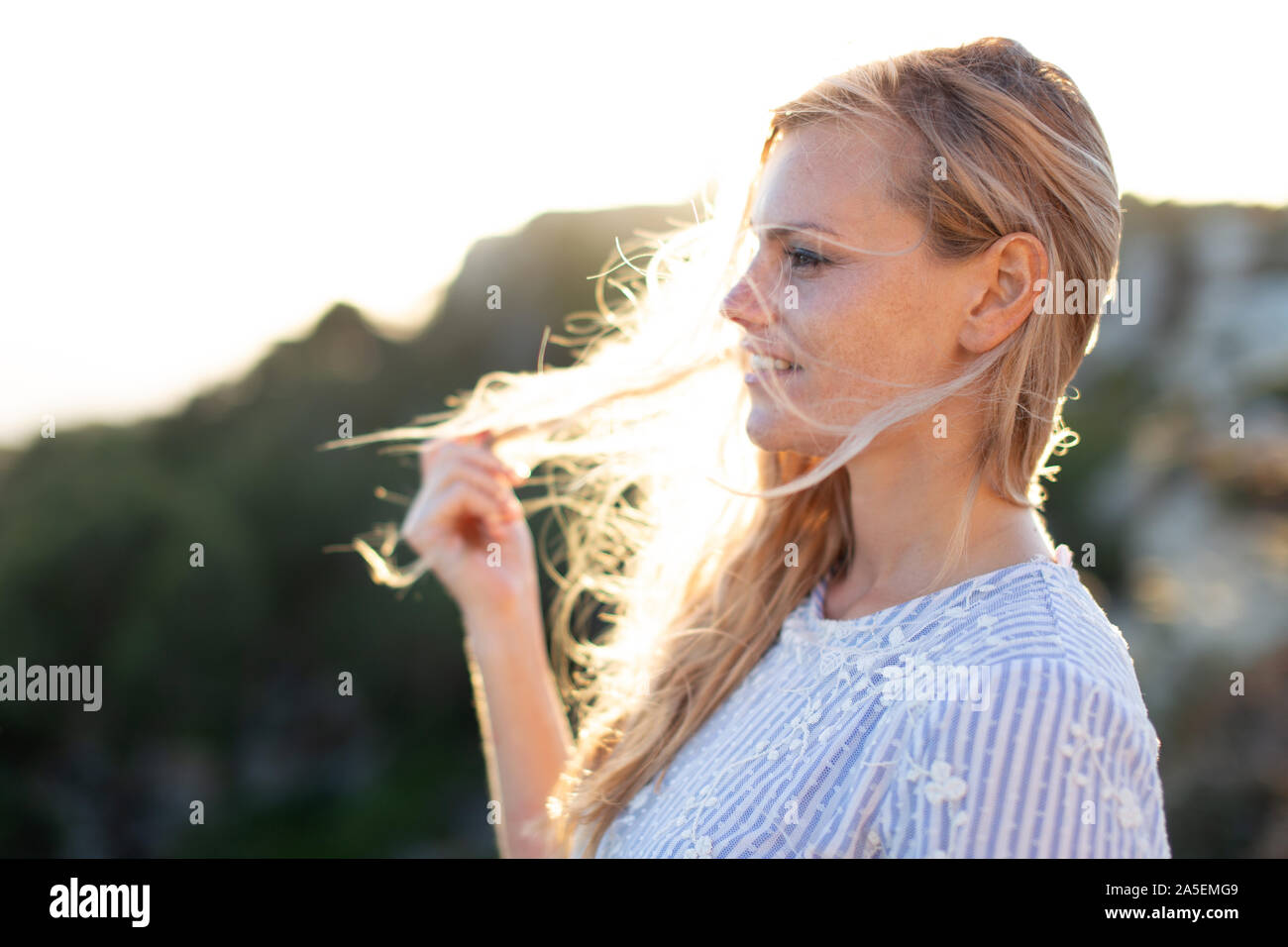 Jeune femme blonde 20s à la voiture Vue de profil dans la nature Banque D'Images