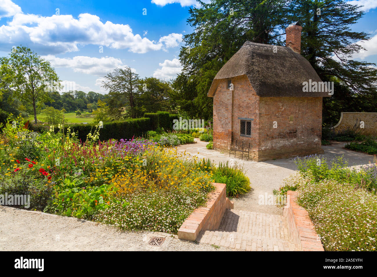 Le Chalet jardin coloré avec sa maison du jardinier de chaume dans le 'nouvellement restauré le triton dans Somerset' garden et hôtel, nr Bruton, Angleterre, U Banque D'Images