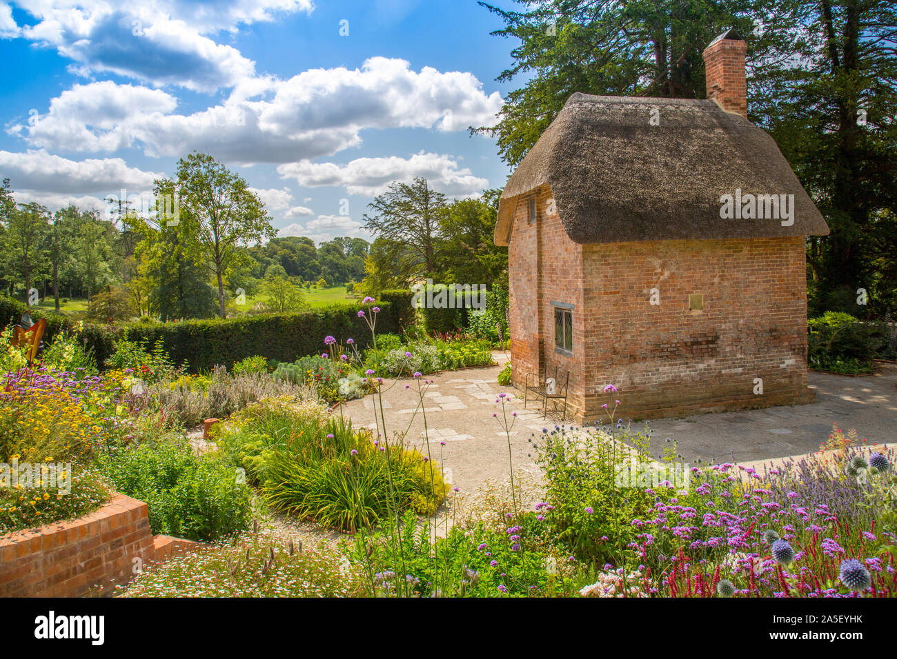 Le Chalet jardin coloré avec sa maison du jardinier de chaume dans le 'nouvellement restauré le triton dans Somerset' garden et hôtel, nr Bruton, Angleterre, U Banque D'Images