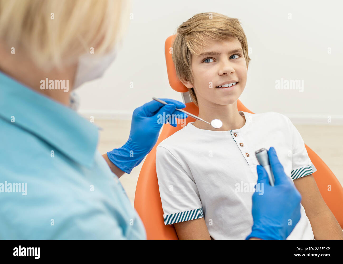 Examen dentaire du garçon blond est sur le point de commencer dans une clinique Banque D'Images