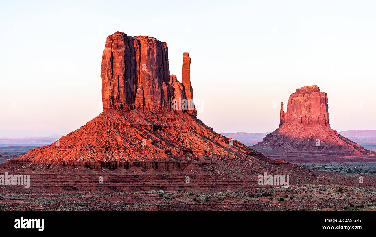 Vue panoramique de deux mitaines butte mesa avec orange rouge coloré couleur rock sur horizon dans Monument Valley canyons pendant le coucher du soleil à Arizona Banque D'Images