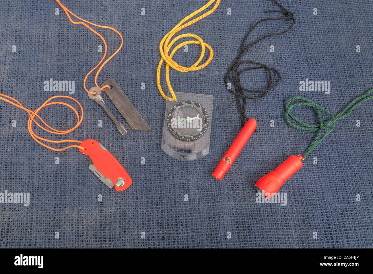 Compétences et équipement de survie. Chasseur de survie à haute visibilité, sifflet de survie, torche de survie à haute viz, couteau à haute viz, boussole de survie, trousse d'urgence. Banque D'Images