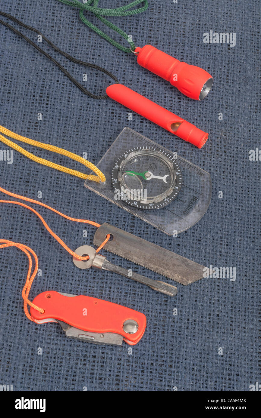 Compétences et équipement de survie. Chasseur de survie à haute visibilité, sifflet de survie, torche de survie à haute viz, couteau à haute viz, boussole de survie, trousse d'urgence. Banque D'Images