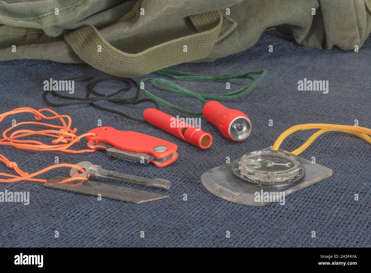 Compétences et équipement de survie. Chasseur de survie à haute visibilité, sifflet de survie, torche de survie à haute viz, couteau à haute viz, boussole de survie, trousse d'urgence. Banque D'Images