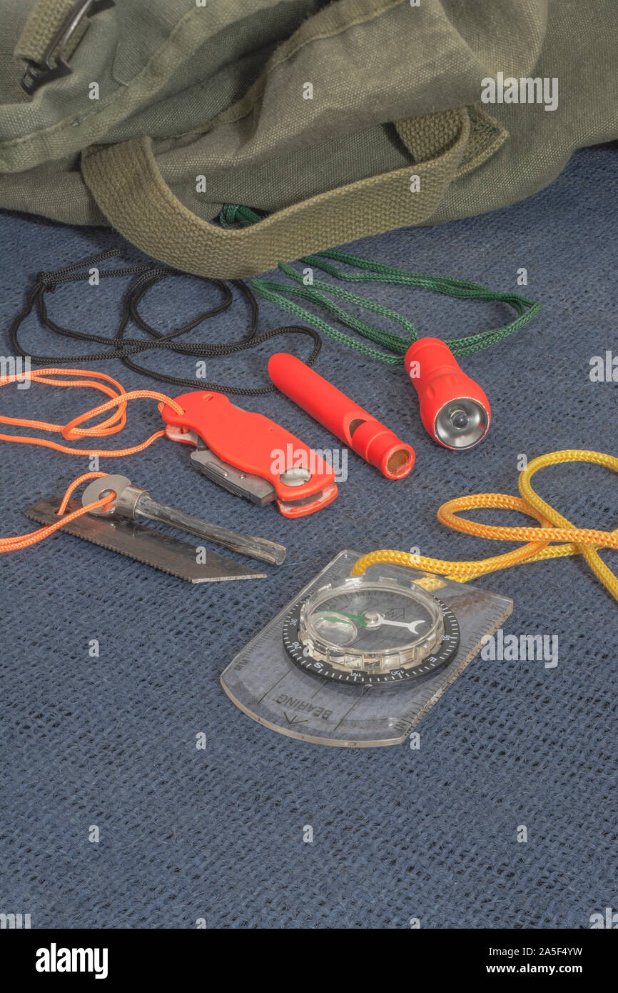 Compétences et équipement de survie. Chasseur de survie à haute visibilité, sifflet de survie, torche de survie à haute viz, couteau à haute viz, boussole de survie, trousse d'urgence. Banque D'Images