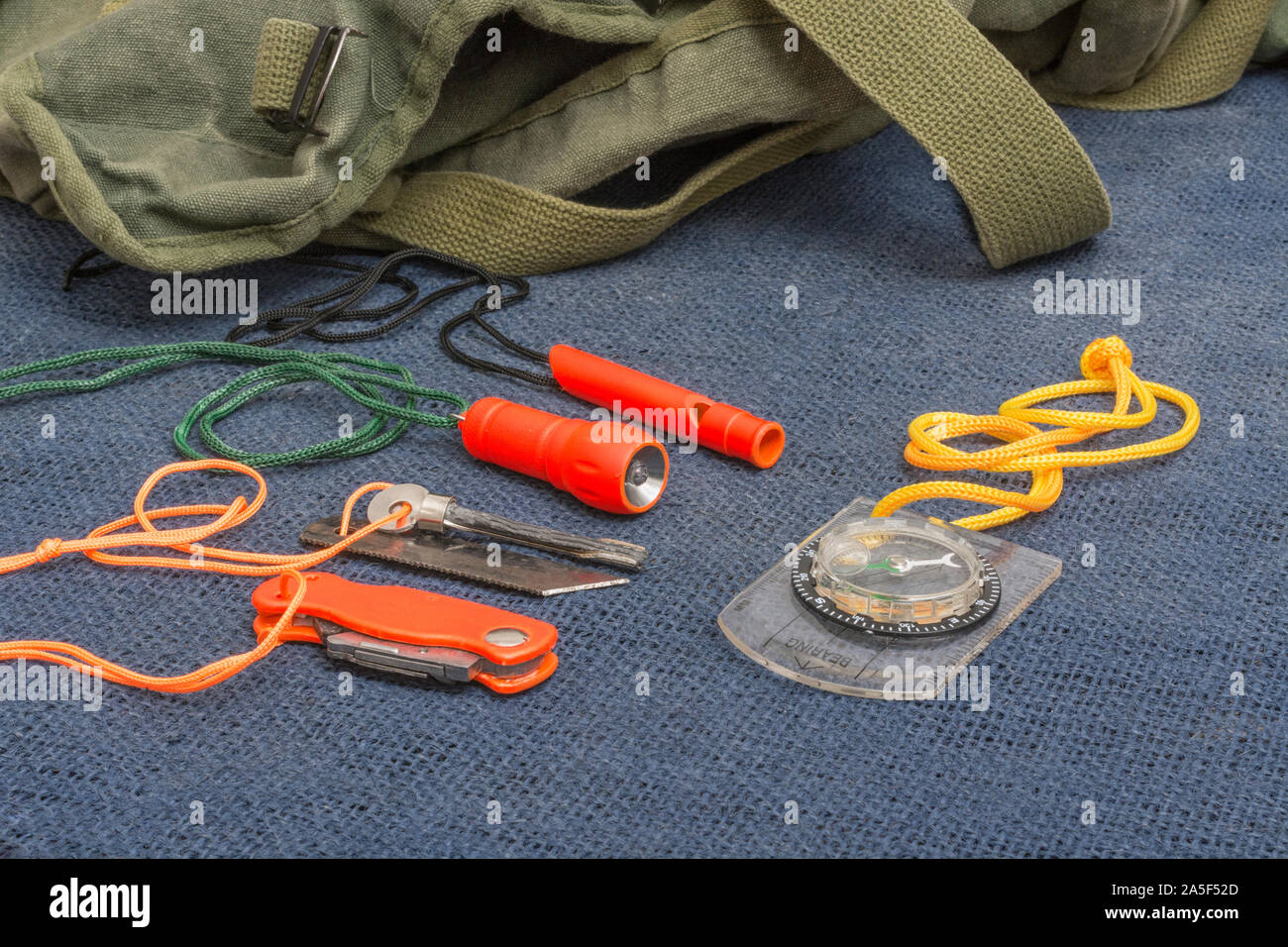 Compétences et équipement de survie. Chasseur de survie à haute visibilité, sifflet de survie, torche de survie à haute viz, couteau à haute viz, boussole de survie, trousse d'urgence. Banque D'Images