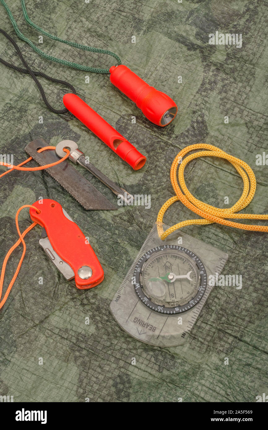 Compétences et équipement de survie. Chasseur de survie à haute visibilité, sifflet de survie, torche de survie à haute viz, couteau à haute viz, boussole de survie, trousse d'urgence. Banque D'Images