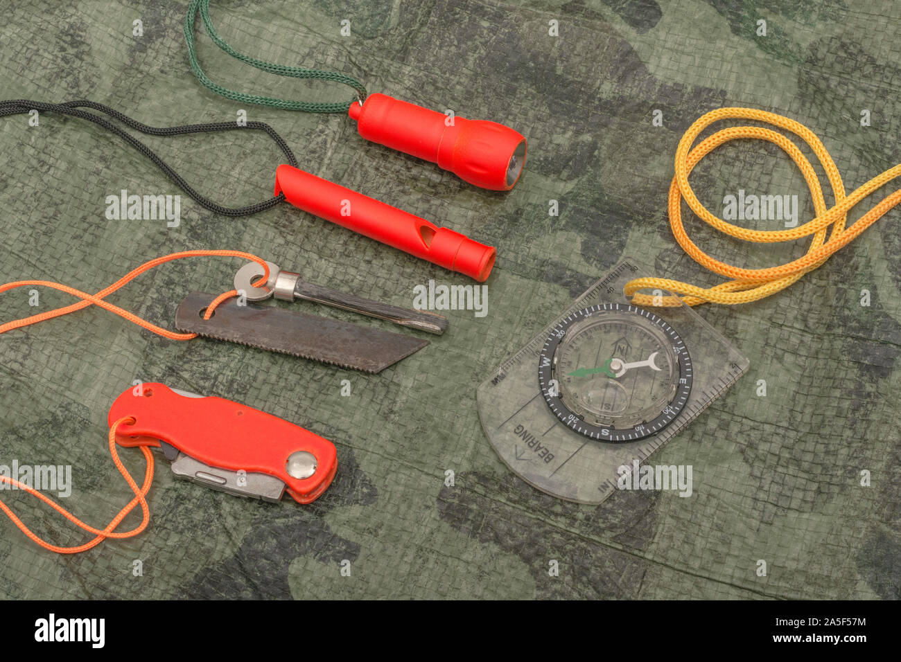 Compétences et équipement de survie. Chasseur de survie à haute visibilité, sifflet de survie, torche de survie à haute viz, couteau à haute viz, boussole de survie, trousse d'urgence. Banque D'Images