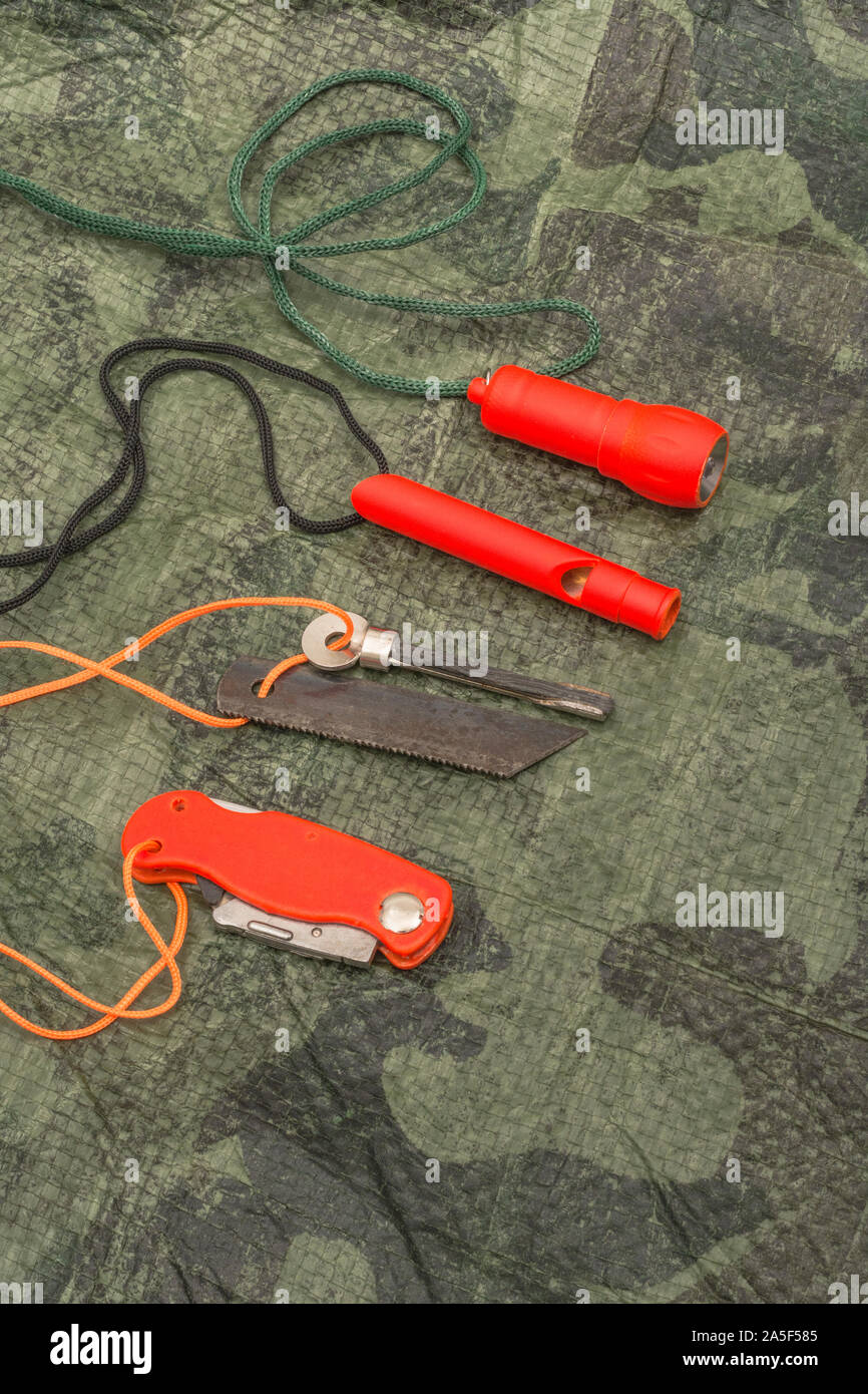 Compétences et équipement de survie. Chasseur de survie à haute visibilité, sifflet de survie, torche de survie à haute viz, couteau à haute viz, boussole de survie, trousse d'urgence. Banque D'Images