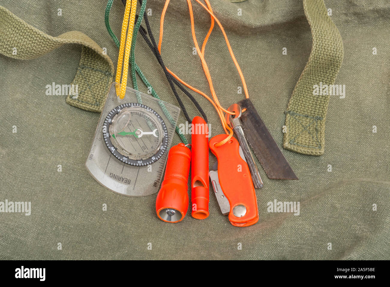 Compétences et équipement de survie. Chasseur de survie à haute visibilité, sifflet de survie, torche de survie à haute viz, couteau à haute viz, boussole de survie, trousse d'urgence. Banque D'Images