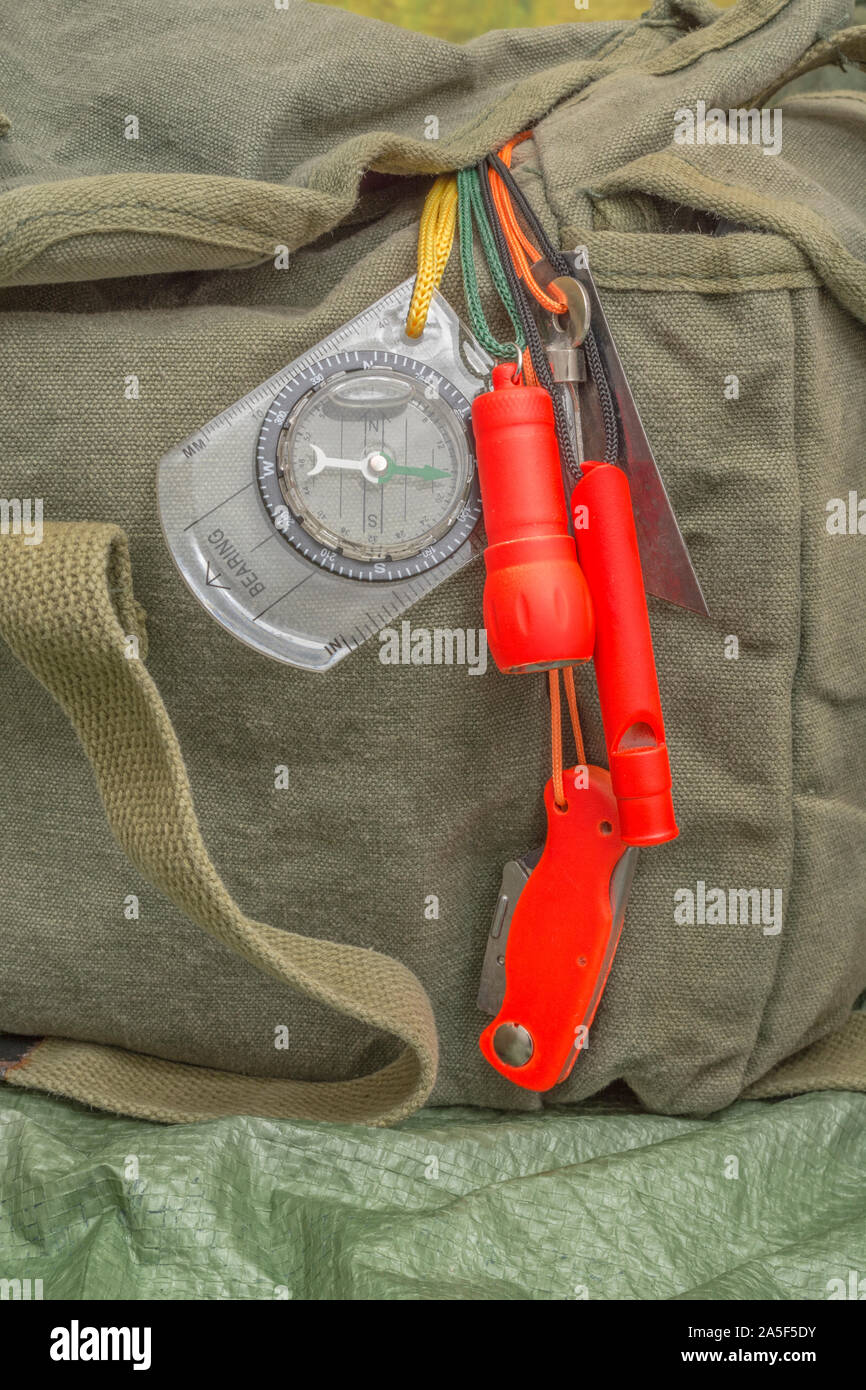 Compétences et équipement de survie. Chasseur de survie à haute visibilité, sifflet de survie, torche de survie à haute viz, couteau à haute viz, boussole de survie, trousse d'urgence. Banque D'Images