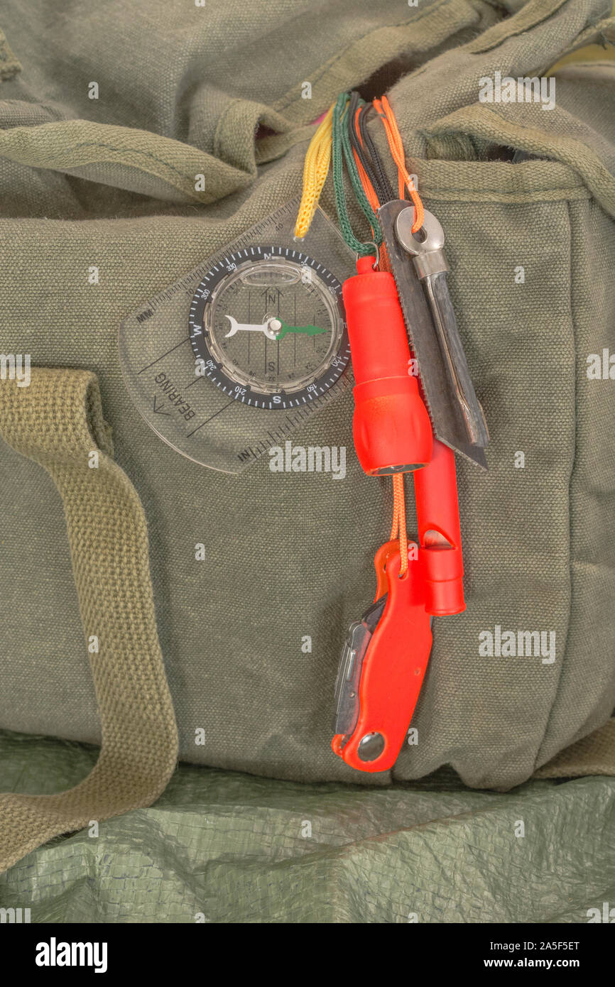 Compétences et équipement de survie. Chasseur de survie à haute visibilité, sifflet de survie, torche de survie à haute viz, couteau à haute viz, boussole de survie, trousse d'urgence. Banque D'Images