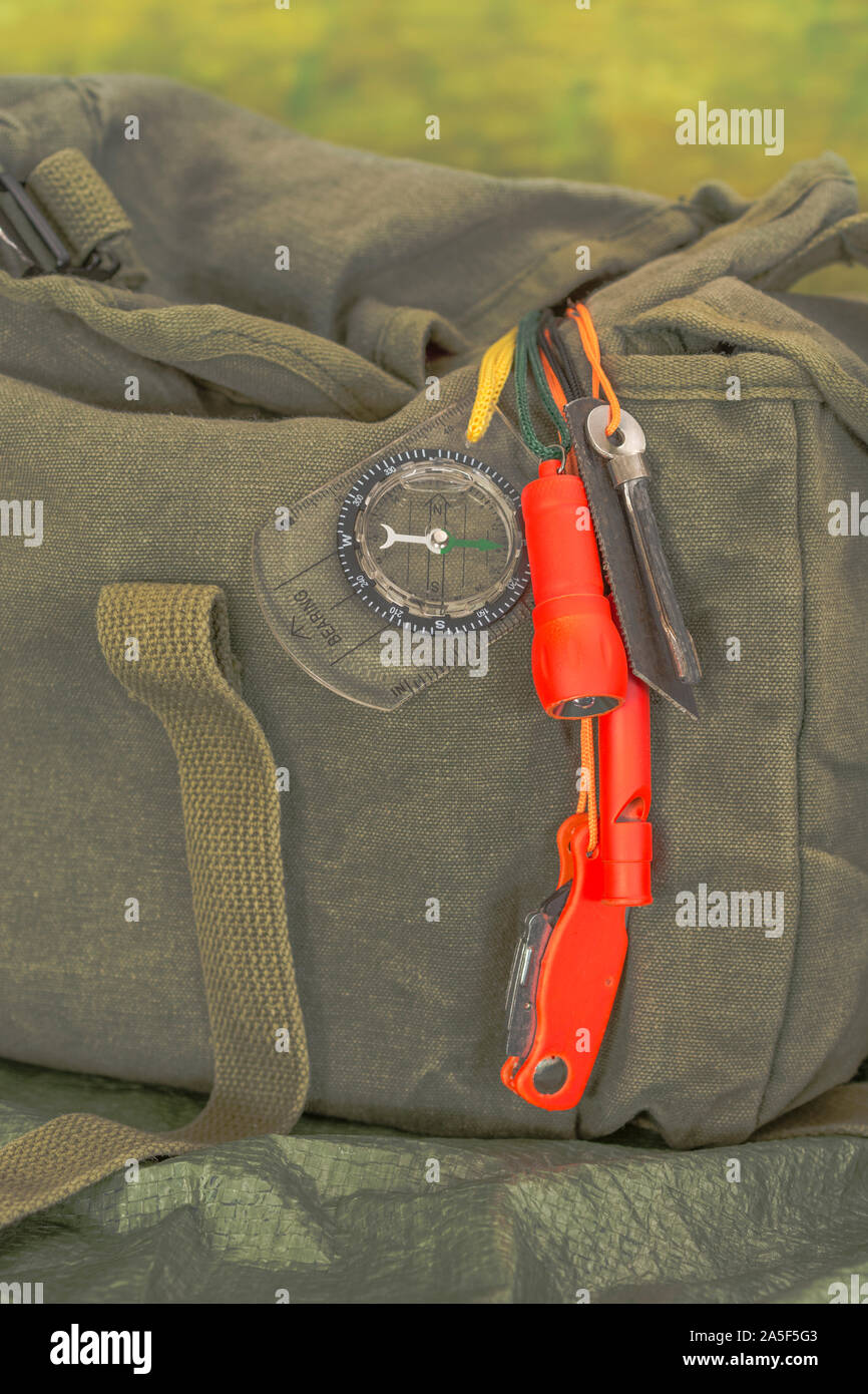 Compétences et équipement de survie. Chasseur de survie à haute visibilité, sifflet de survie, torche de survie à haute viz, couteau à haute viz, boussole de survie, trousse d'urgence. Banque D'Images