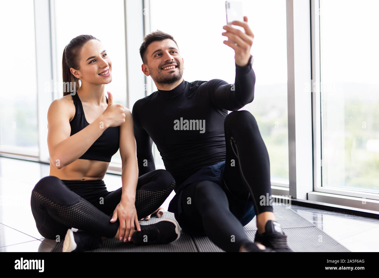 Jeune couple à selfies sport. L'homme et la femme athlète taking photo sur smartphone avoir pause après la formation, copy space Banque D'Images