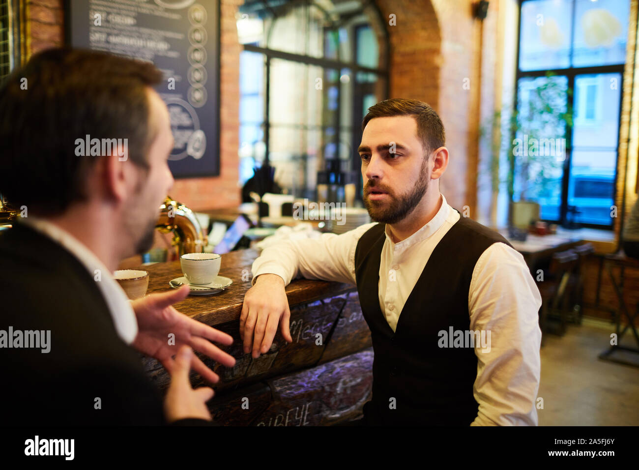 Portrait de deux des gens d'affaires qui ont réussi à parler assis au bar après le travail et la détente, l'espace de copie Banque D'Images