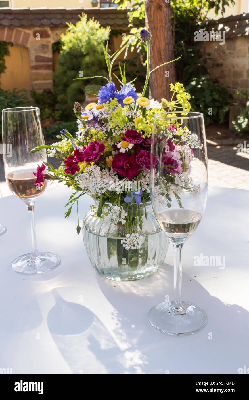 Sektgläser auf einem Tisch, mit Blumenstrauß festlich arrangiert Banque D'Images