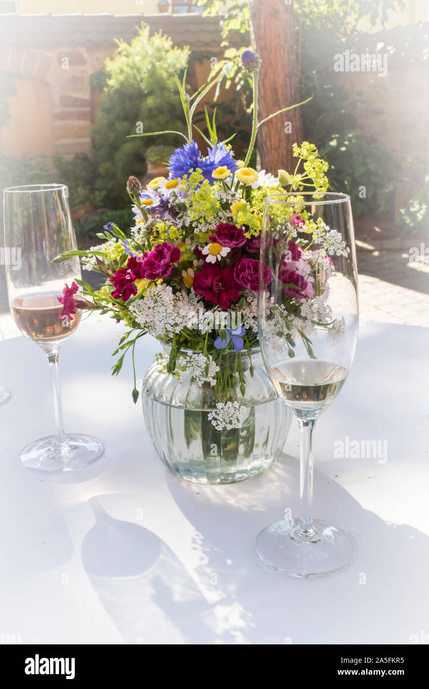 Sektgläser auf einem Tisch, mit Blumenstrauß festlich arrangiert Banque D'Images