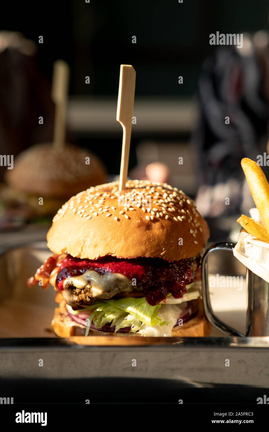 Cheeseburger avec frites et sauce aux canneberges sur un plateau Banque D'Images