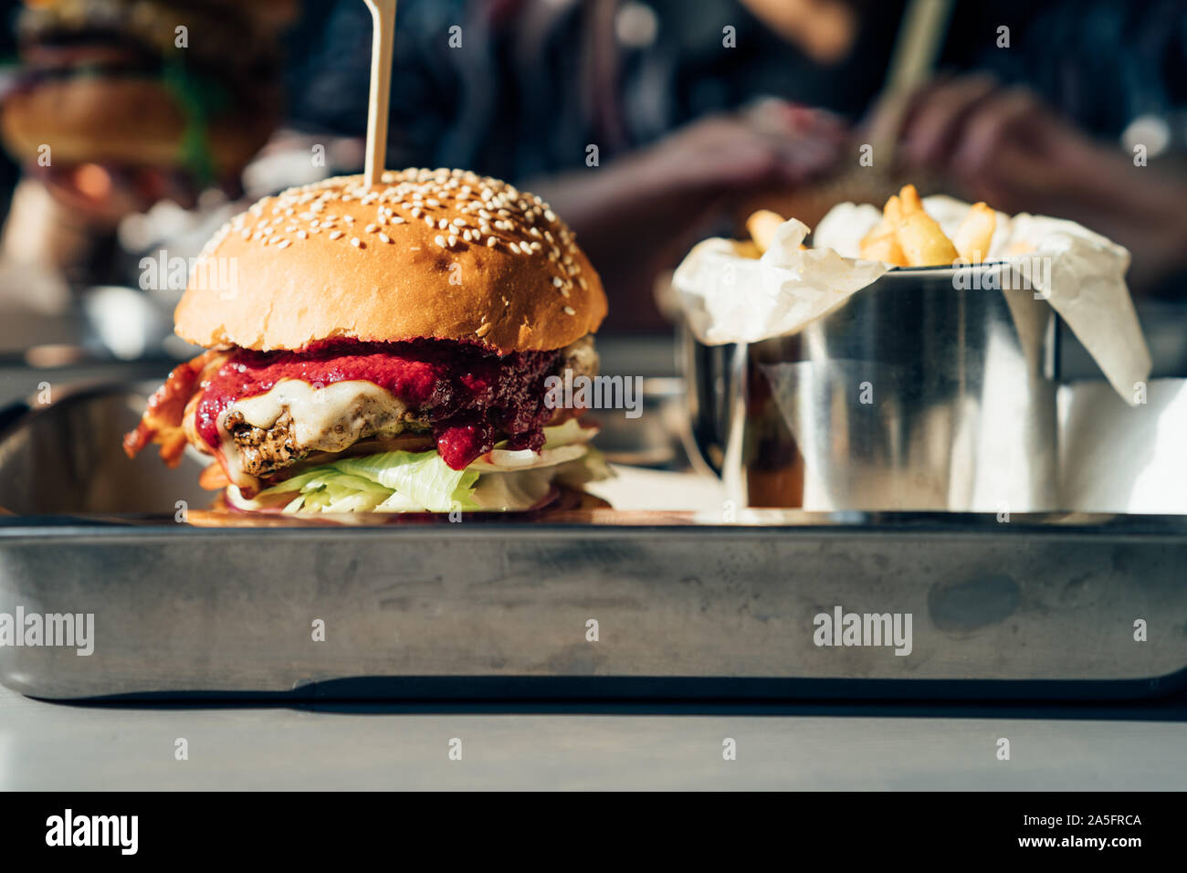 Cheeseburger avec frites et sauce aux canneberges sur un plateau Banque D'Images