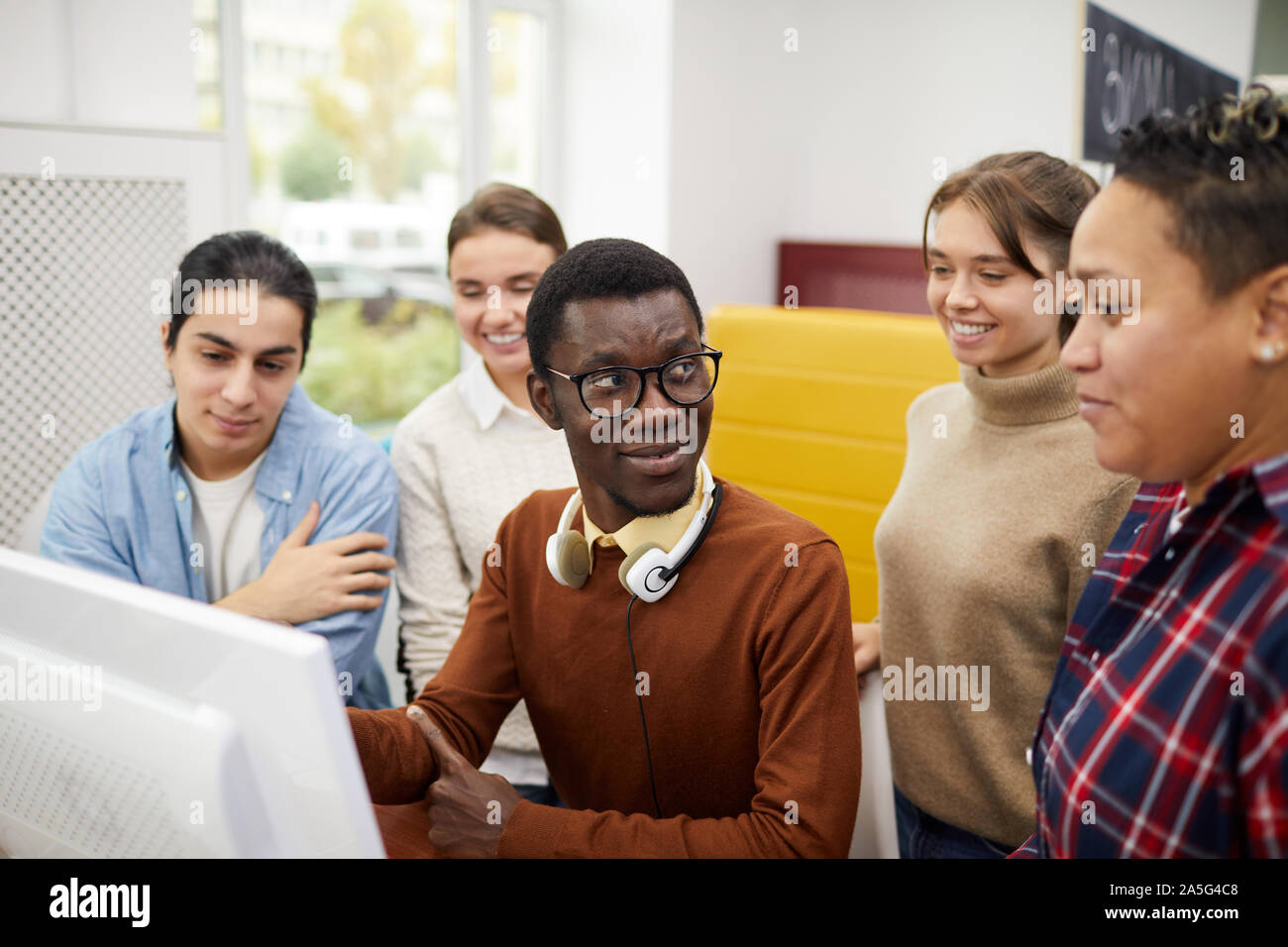 Portrait de groupe multiethnique d'étudiants à l'aide d'ordinateur lors de mes recherches pour le projet de l'équipe in library Banque D'Images