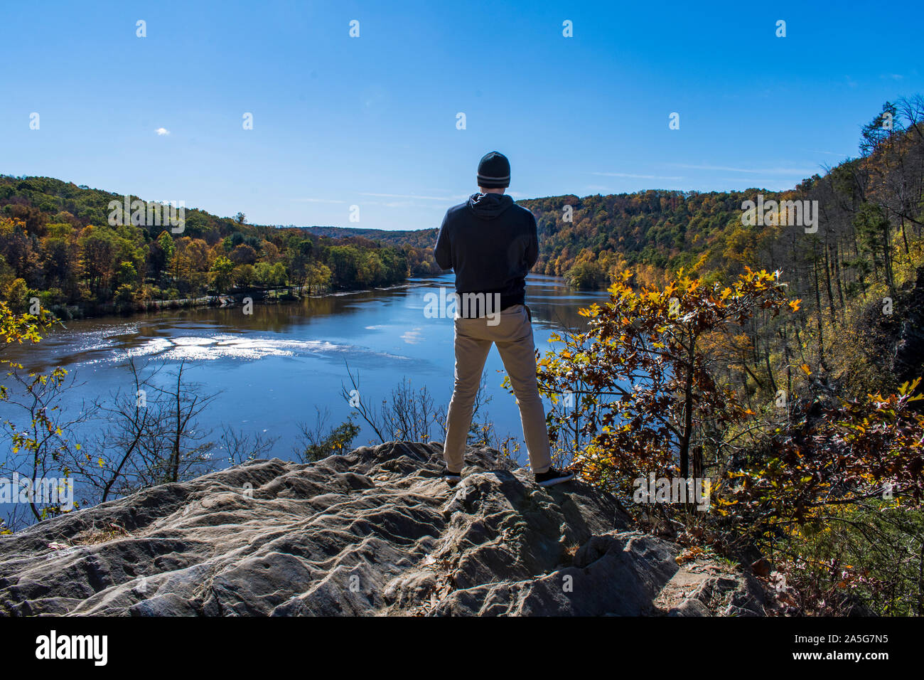 Scène d'automne d'un homme vu de dos regardant river à partir de la falaise Banque D'Images