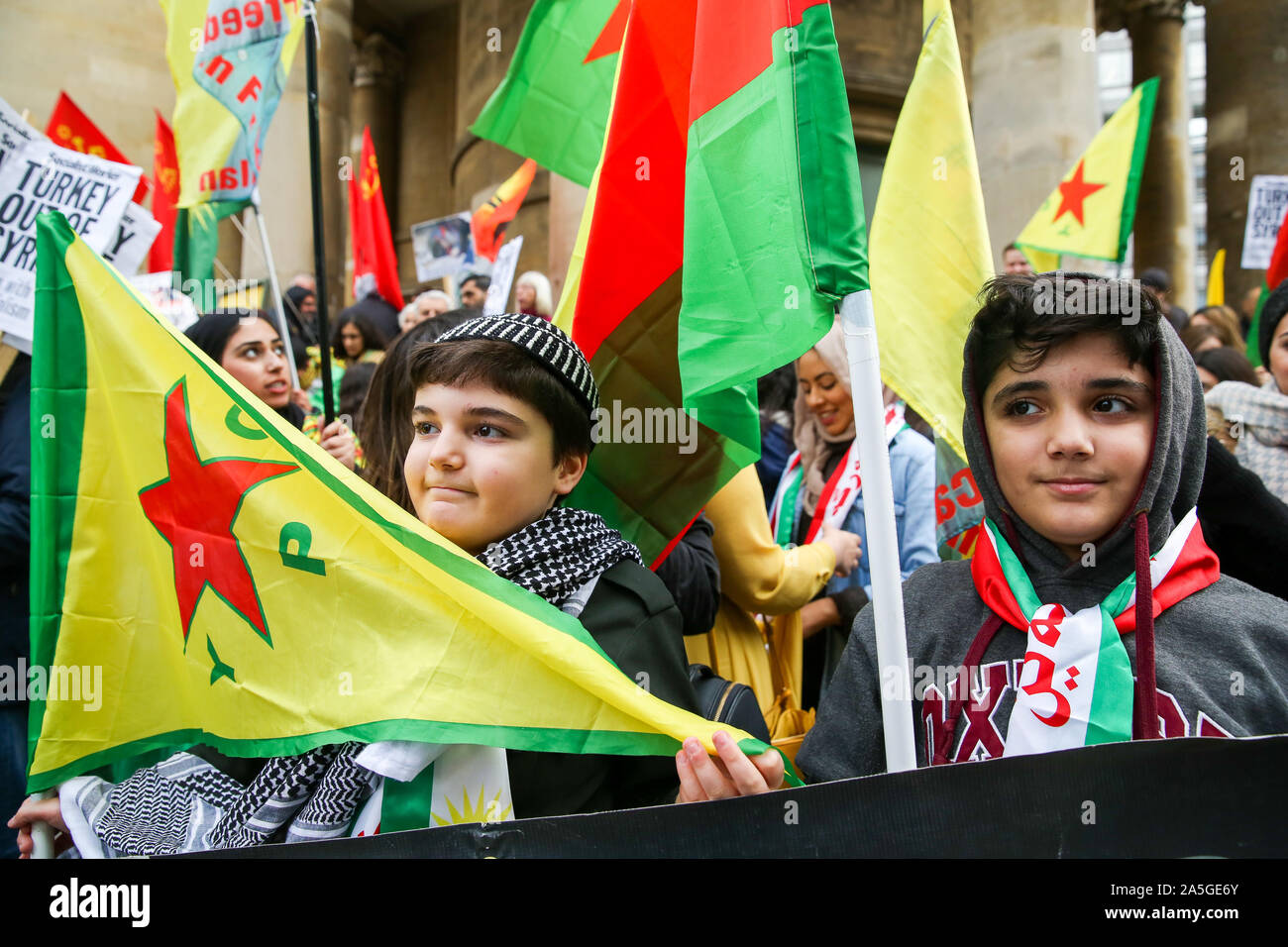 Londres, Royaume-Uni. 20 Oct, 2019. Deux jeunes manifestants kurdes avec des drapeaux au cours de la démonstration.Les manifestants ont appelé à une mobilisation de masse dans le monde entier et des actions contre l'armée turque dans le nord de la Syrie. Le 9 octobre 2019 Le président américain, Donald Trump a annoncé que les troupes américaines vont tirer vers l'arrière de la zone. Credit : SOPA/Alamy Images Limited Live News Banque D'Images
