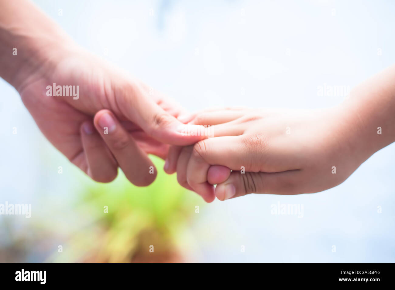 La main de l'enfant de sexe féminin qui tient la main d'un homme tourné avec arrière-plan flou et l'horizontale. Concept de la fête des pères (16 juin). Banque D'Images
