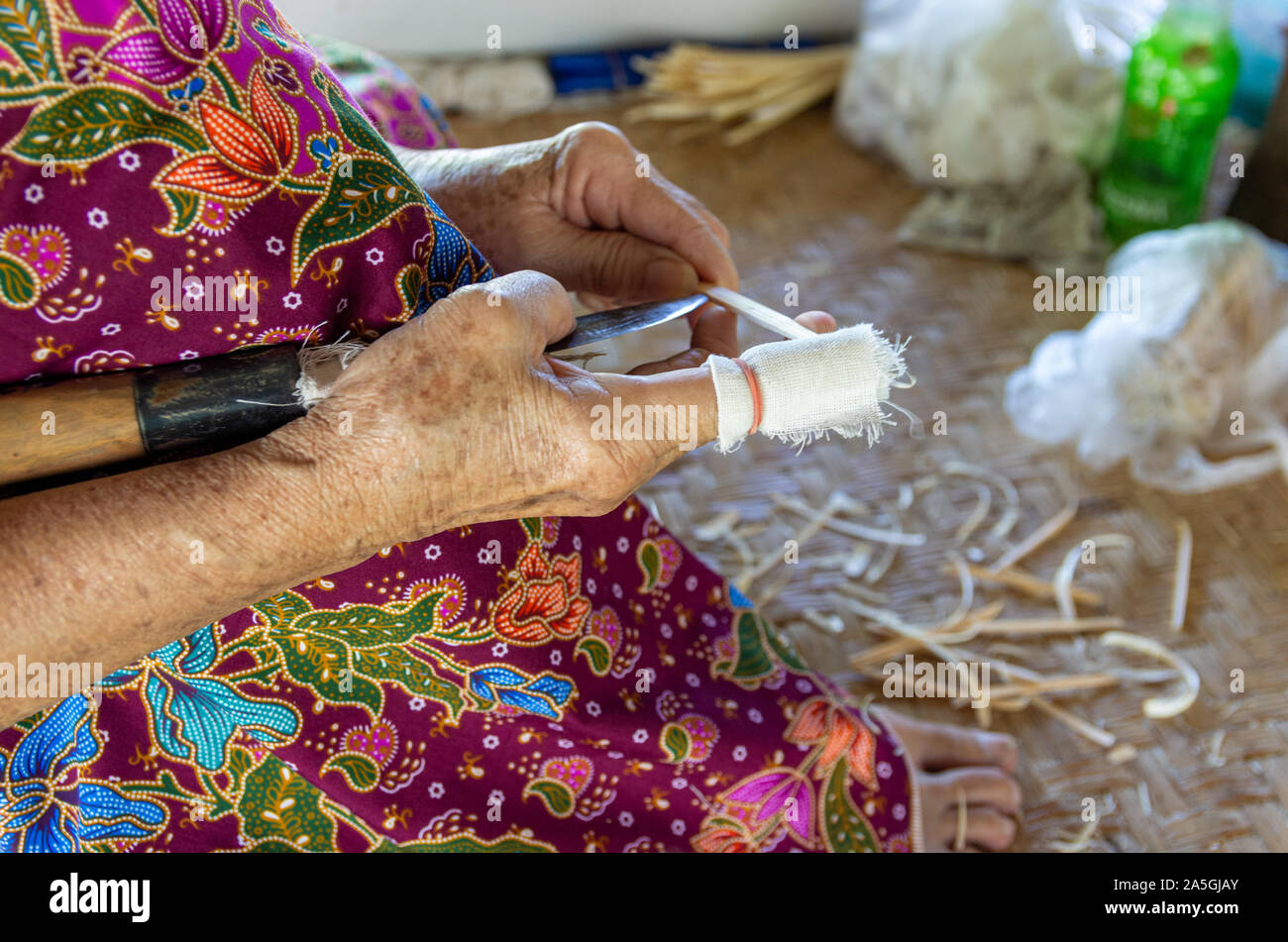 Gros plan des mains senior faisant des parties de parasols thaïlandais traditionnels Banque D'Images