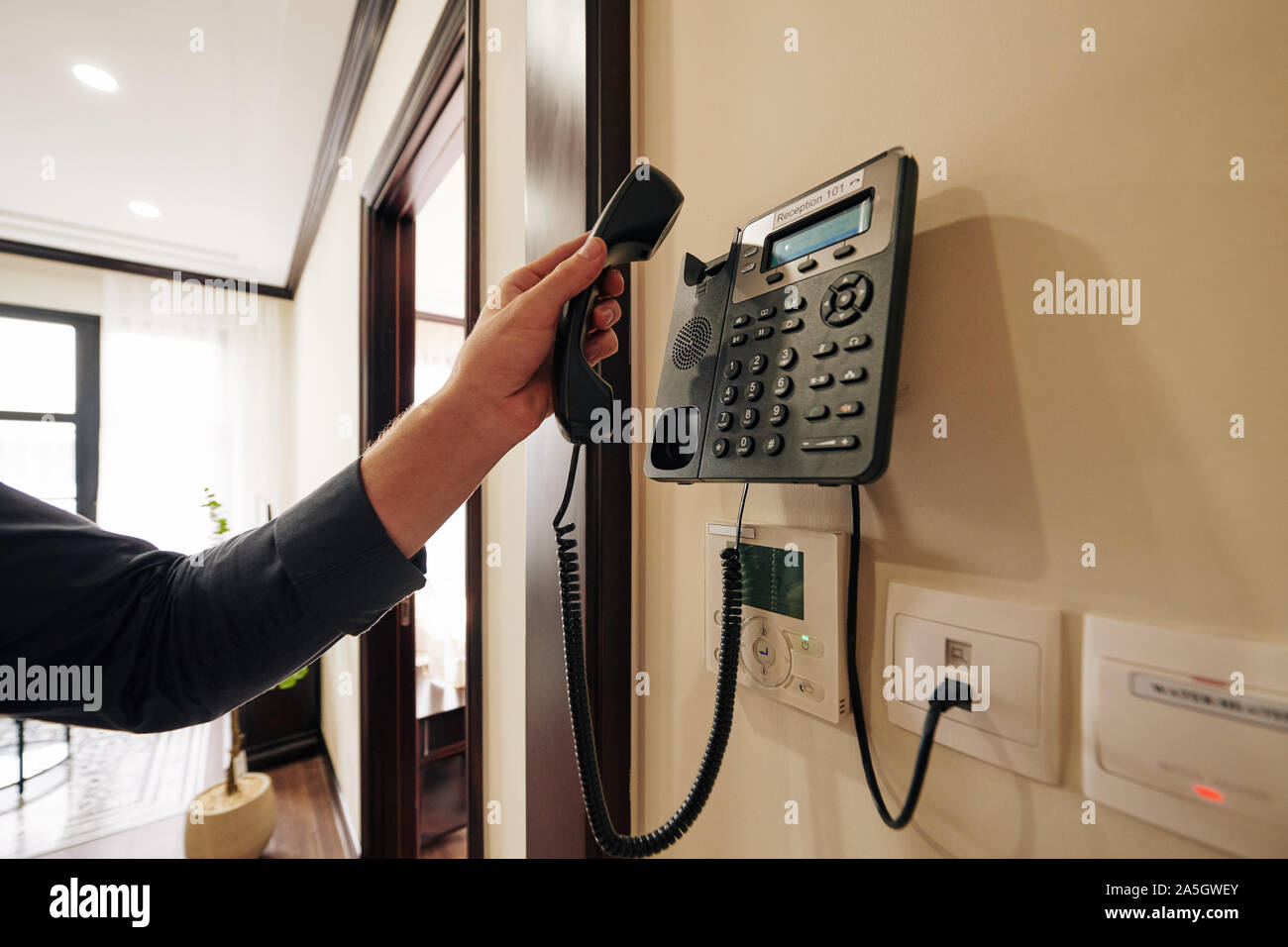 Portrait de l'homme à l'aide de téléphone dans la chambre d'hôtel à commander de la nourriture et des boissons ou service de nettoyage Banque D'Images