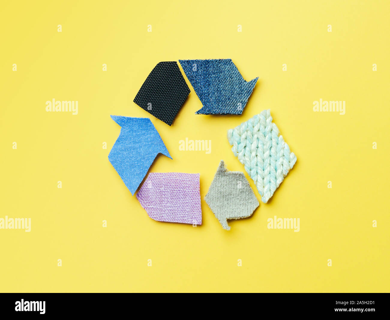 Réutiliser, réduire, recycler concept arrière-plan. Le vert réutilisent le fait à partir de vieux vêtements sur fond jaune. Vue de dessus ou de télévision. Banque D'Images