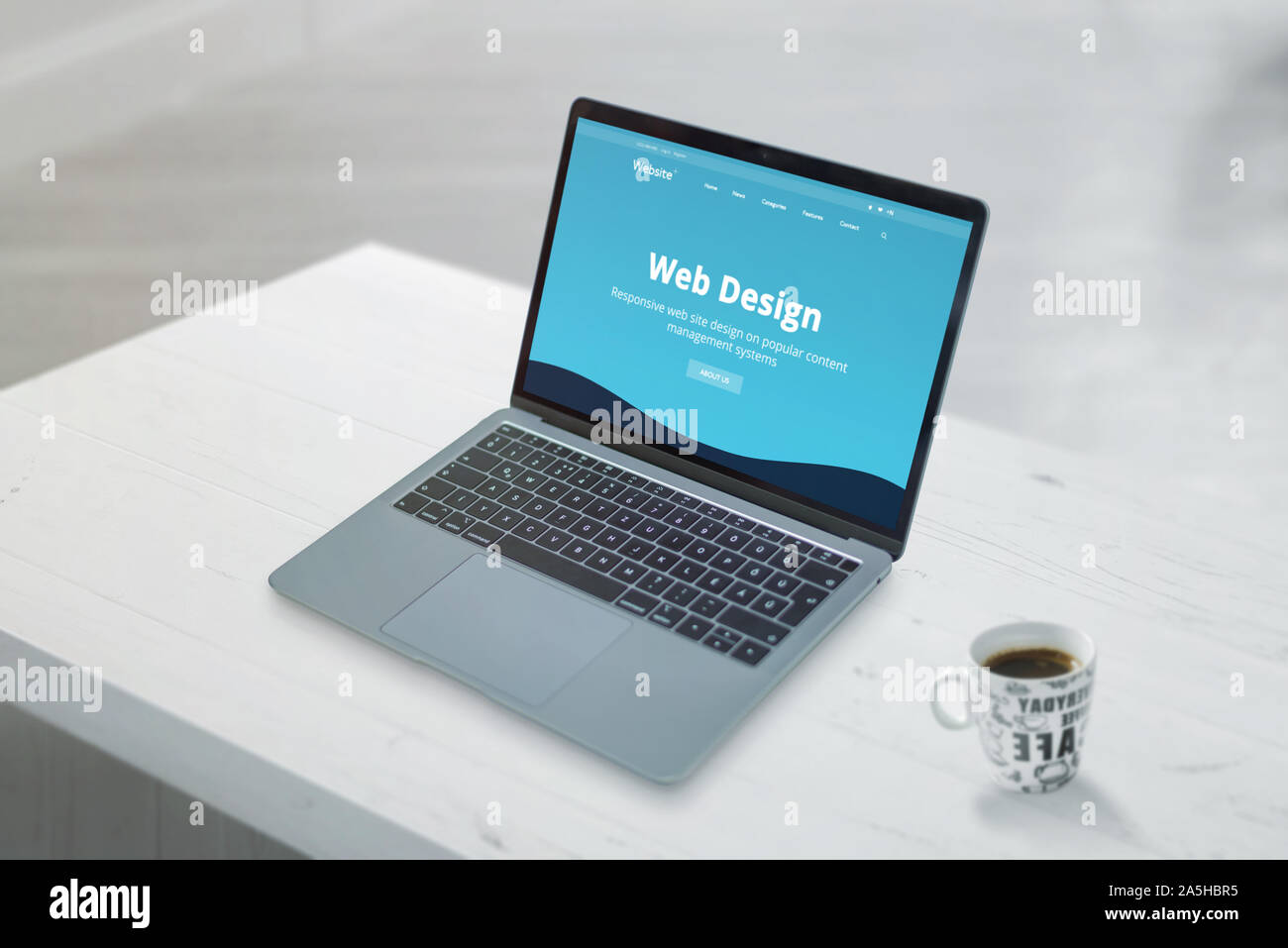 Design et propre promo web design studio web page on laptop concept. Close-up scène de travail de bureau 24. Tasse de café à côté. Banque D'Images