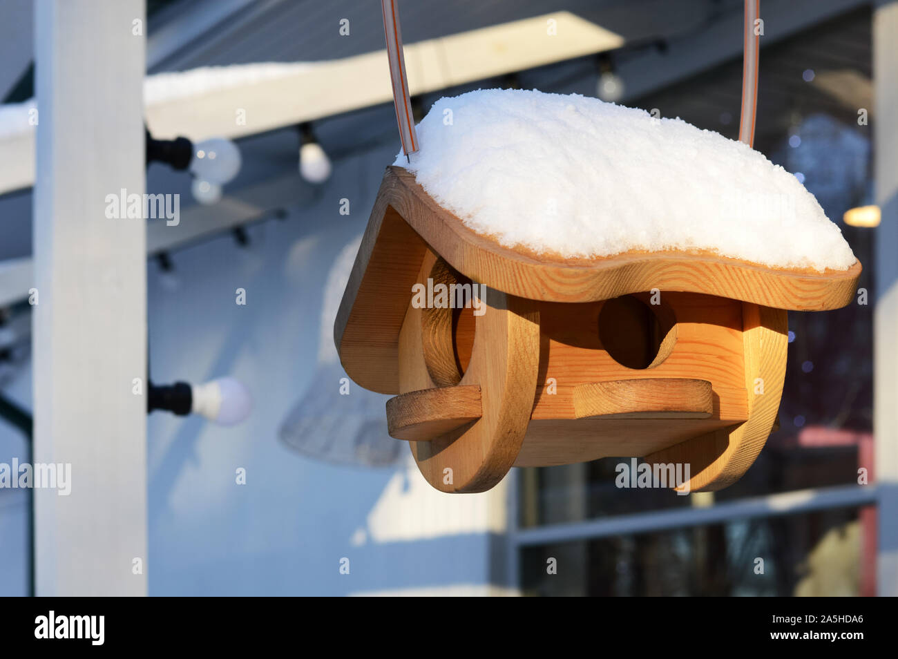 En bois faits maison ou maison d'oiseau mangeoire avec de la neige sur le toit d'une journée ensoleillée d'hiver Banque D'Images